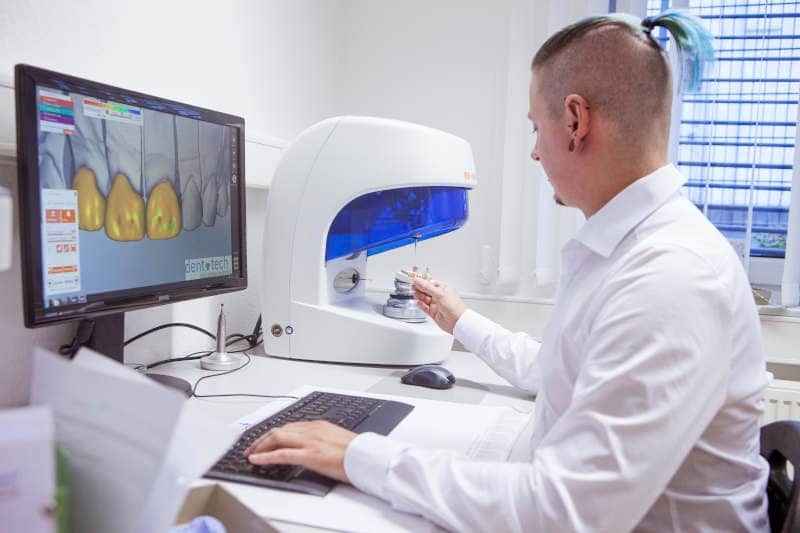 Partner für Zahnärzte, Zahn­techniker und Dental­labore - Mitarbeiter von Dent-Tech bediehnt einen 3D Scanner